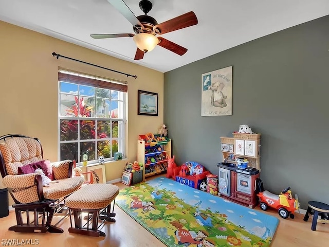 recreation room with light hardwood / wood-style floors and ceiling fan