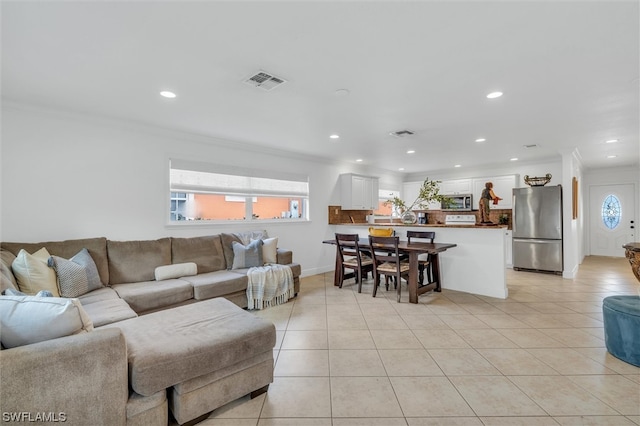 living room with light tile flooring and crown molding