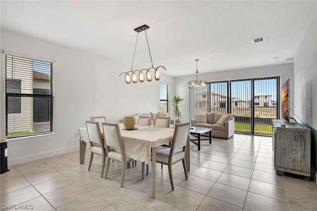 tiled dining room featuring a notable chandelier