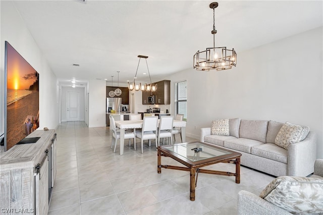 tiled living room featuring a notable chandelier