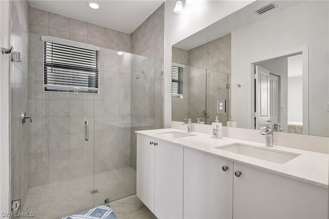 bathroom with tile flooring, double sink, a shower with shower door, and oversized vanity