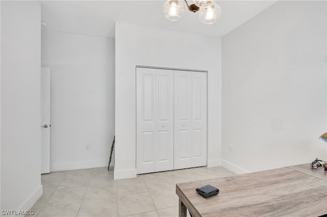 interior space with a chandelier, a closet, and light tile floors