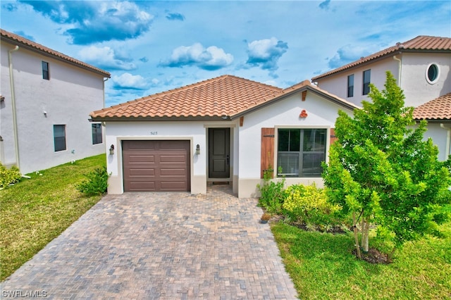 mediterranean / spanish home with a front yard and a garage