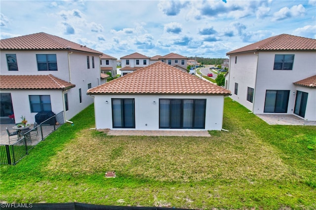 back of property with a patio and a yard