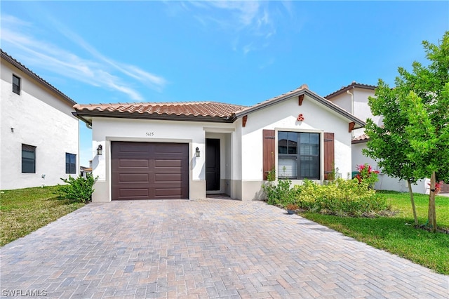 mediterranean / spanish home featuring a front yard and a garage