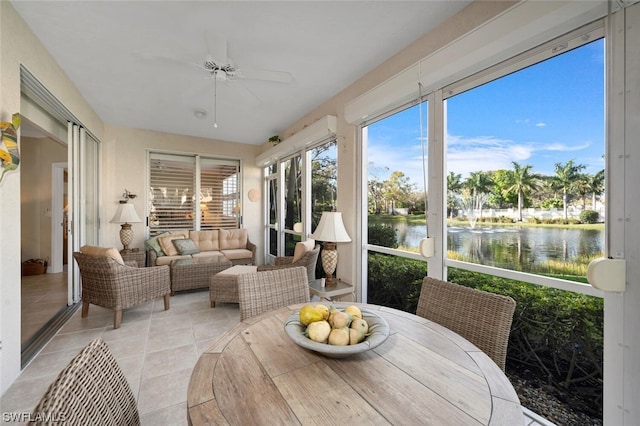 sunroom / solarium with ceiling fan and a water view