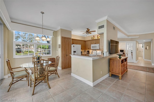 kitchen with light tile flooring, ornamental molding, white appliances, and ceiling fan with notable chandelier