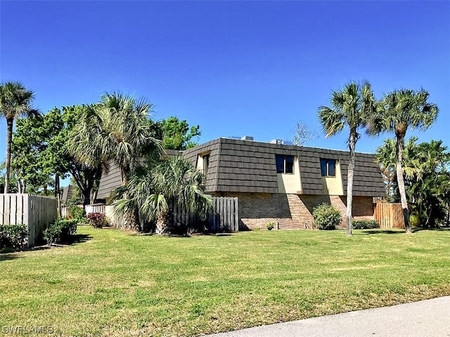 view of side of home with a yard