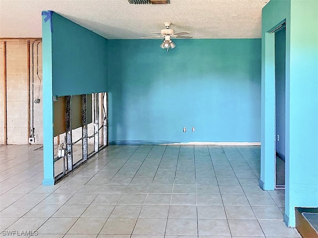 tiled spare room featuring ceiling fan and a textured ceiling