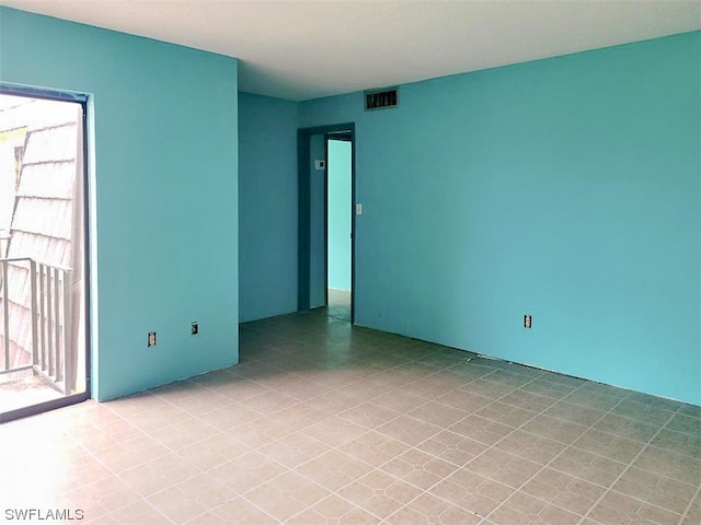 tiled empty room featuring a wealth of natural light