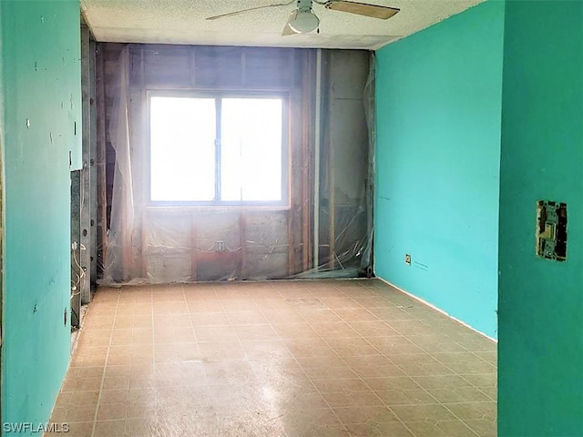 spare room with light tile floors, a textured ceiling, and ceiling fan