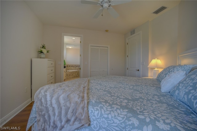 bedroom with connected bathroom, a closet, ceiling fan, and dark wood-type flooring