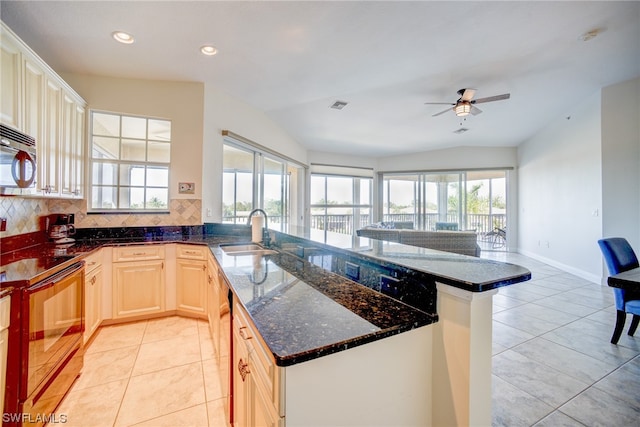 kitchen with ceiling fan, sink, range with electric cooktop, backsplash, and light tile flooring