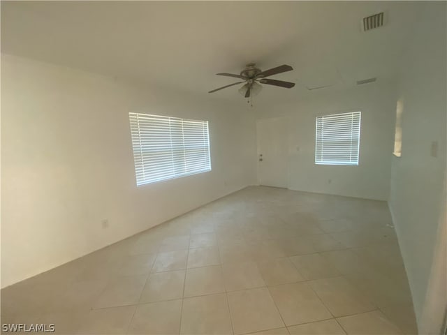 spare room featuring ceiling fan and light tile floors