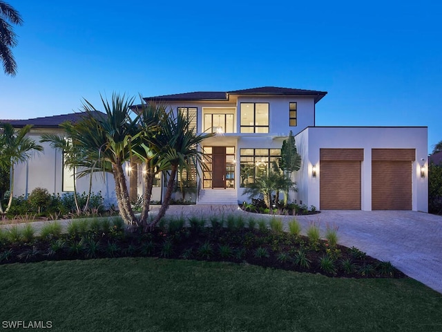 view of front of home featuring a garage and a lawn