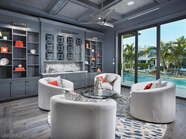 sitting room with hardwood / wood-style flooring, coffered ceiling, and beam ceiling