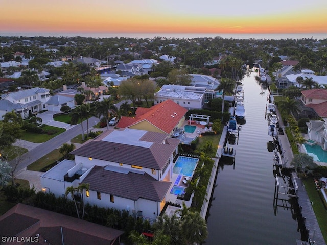 aerial view at dusk featuring a water view