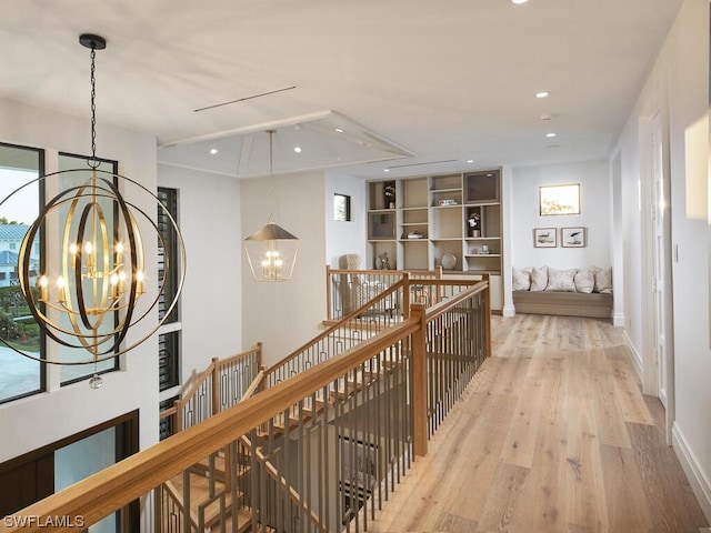 hall with a notable chandelier and light hardwood / wood-style flooring