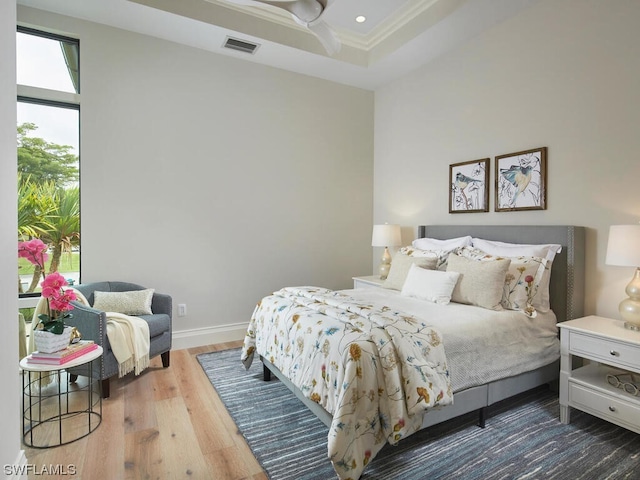 bedroom featuring crown molding, a tray ceiling, and dark hardwood / wood-style floors