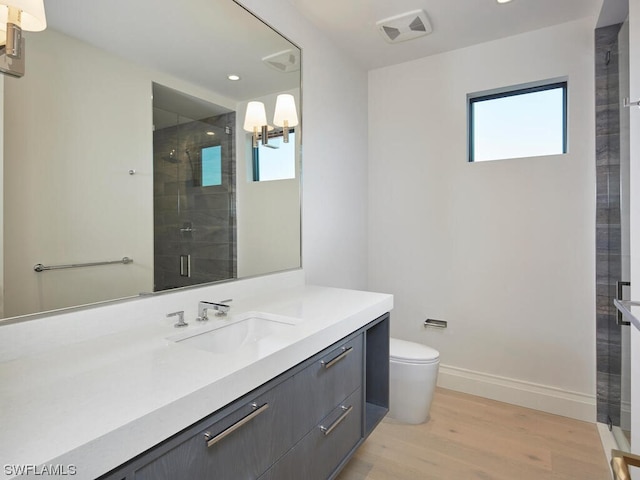 bathroom featuring a shower with door, wood-type flooring, vanity, and toilet