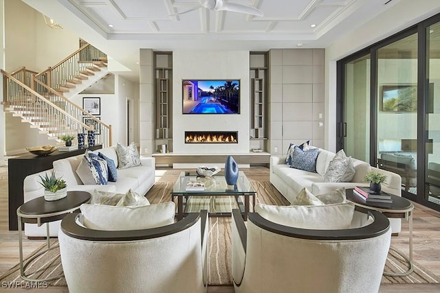 living room featuring coffered ceiling and light hardwood / wood-style floors