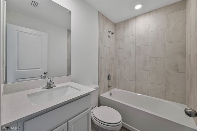 full bathroom featuring tiled shower / bath combo, vanity, and toilet