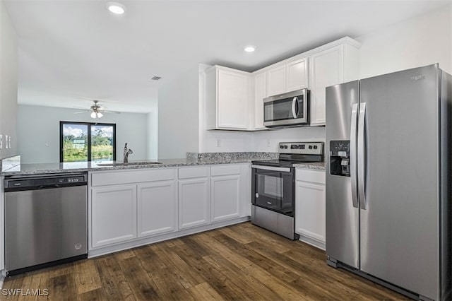 kitchen featuring sink, stainless steel appliances, white cabinets, and light stone countertops