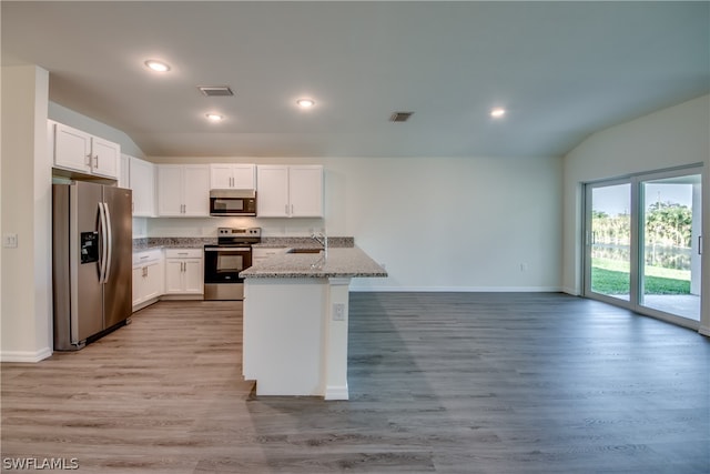 kitchen with sink, light stone counters, white cabinets, stainless steel appliances, and light wood-type flooring