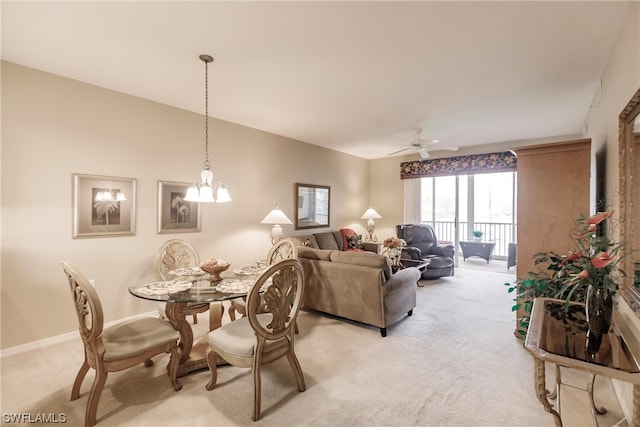 carpeted dining space featuring ceiling fan with notable chandelier