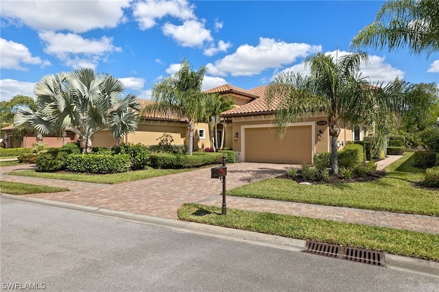 mediterranean / spanish home with a garage and a front yard