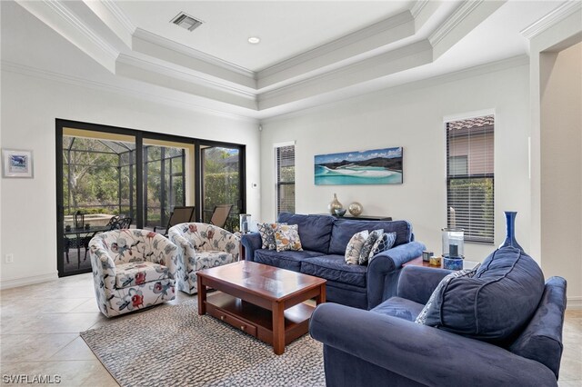 tiled living room with crown molding and a tray ceiling