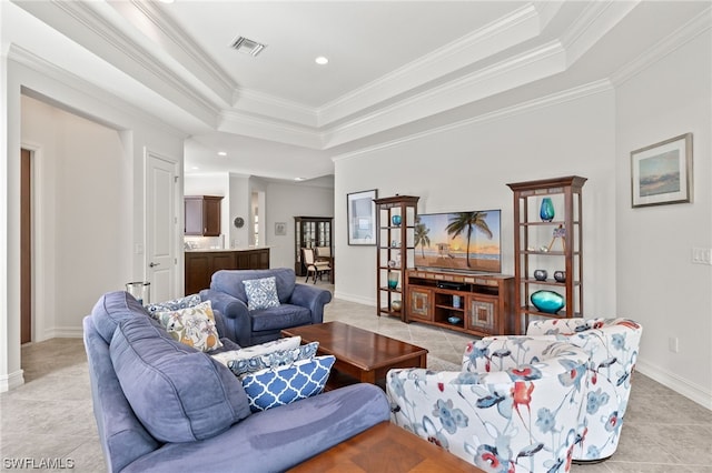 tiled living room with ornamental molding and a tray ceiling