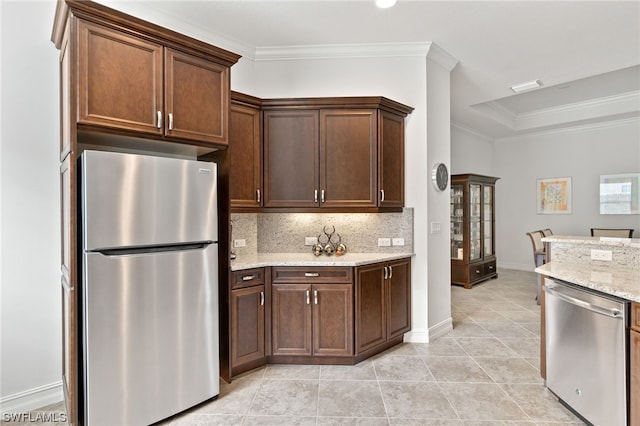 kitchen with stainless steel appliances, crown molding, backsplash, and light stone counters