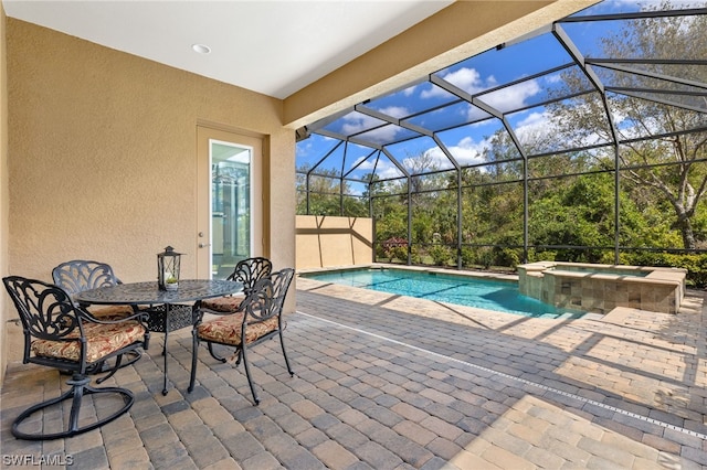 view of pool featuring an in ground hot tub, glass enclosure, and a patio area