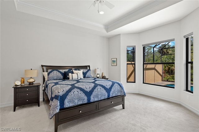 carpeted bedroom featuring ornamental molding, ceiling fan, and a tray ceiling