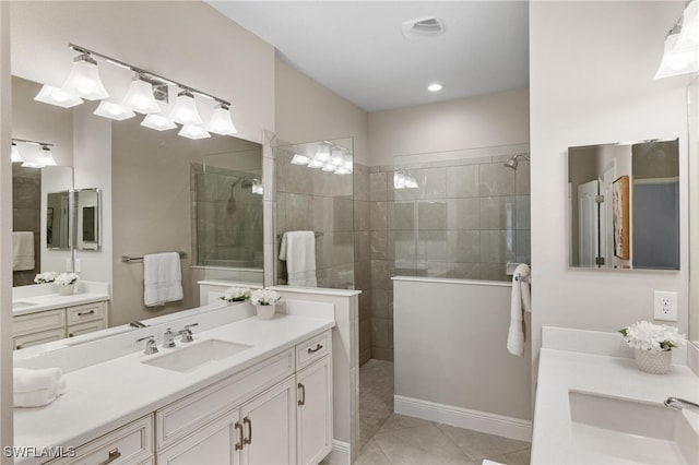 bathroom featuring tiled shower, tile patterned flooring, and vanity