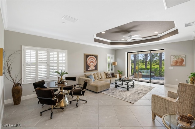 living room featuring a tray ceiling, ornamental molding, and ceiling fan