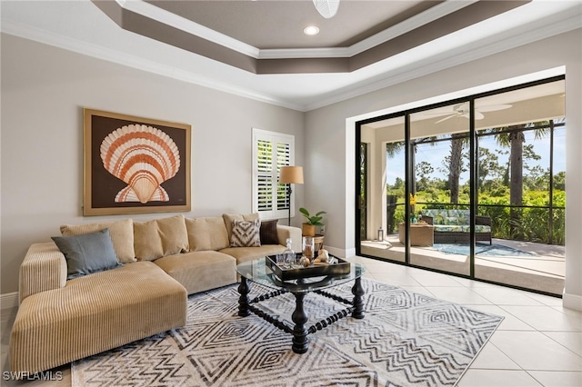 tiled living room featuring crown molding, ceiling fan, and a raised ceiling