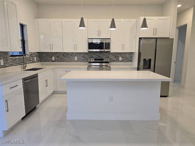 kitchen with pendant lighting, a kitchen island, white cabinetry, and appliances with stainless steel finishes