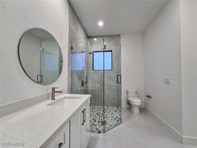 bathroom featuring vanity, a shower with door, and toilet