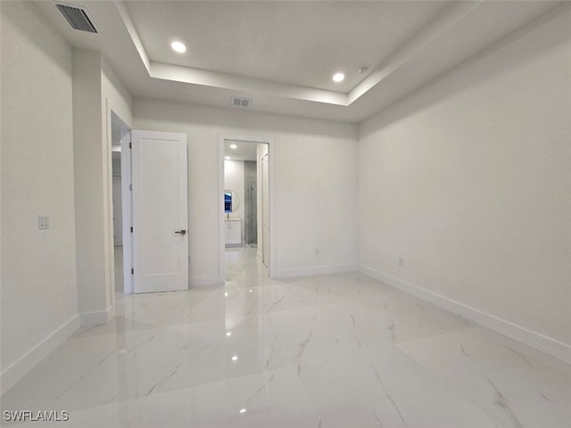 spare room featuring a raised ceiling