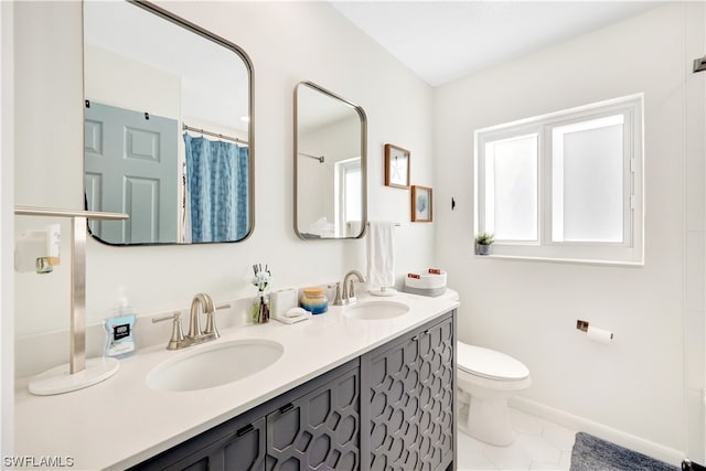 bathroom with toilet, double sink vanity, and tile flooring