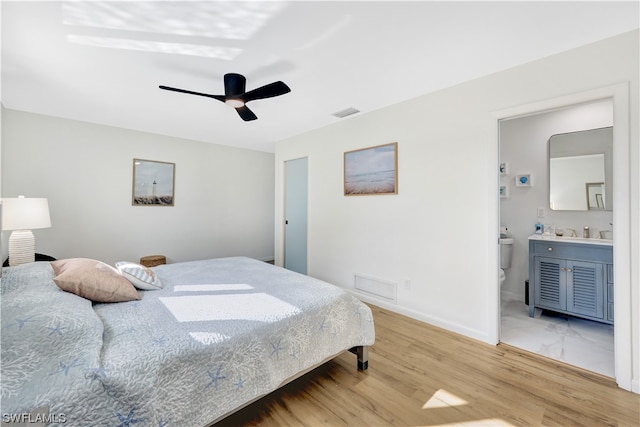 tiled bedroom with ensuite bath, ceiling fan, and sink