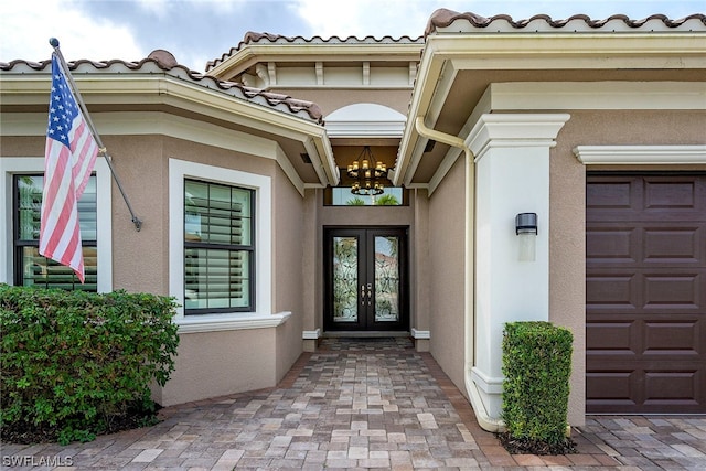 entrance to property featuring a garage and french doors