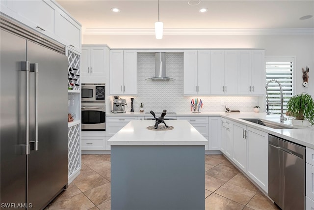 kitchen with sink, a center island, wall chimney range hood, built in appliances, and pendant lighting