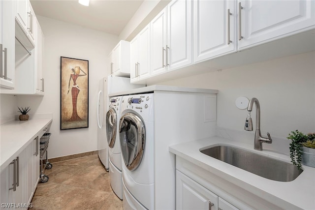 laundry room featuring independent washer and dryer, light tile floors, cabinets, and sink