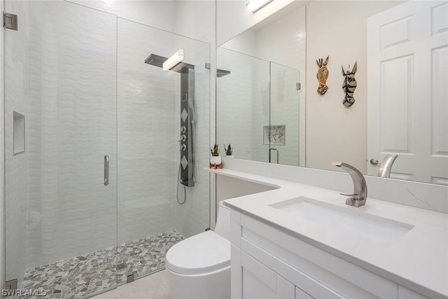 bathroom featuring vanity, a shower with shower door, and toilet