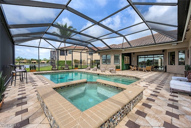 view of pool featuring a patio area, an in ground hot tub, and glass enclosure