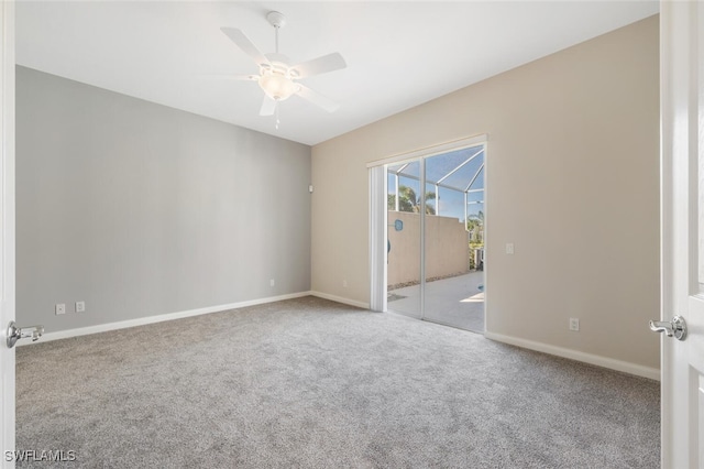 carpeted spare room featuring baseboards and a ceiling fan