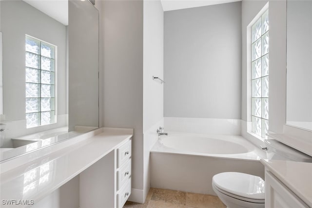 full bathroom featuring a garden tub, vanity, and toilet